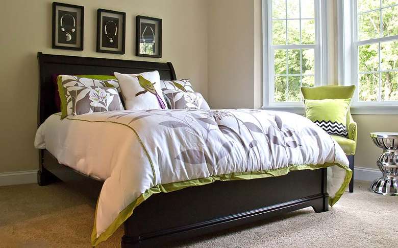 bedroom with a bed with floral and bird blanket and pillows