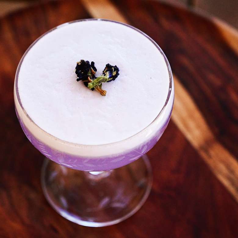 a purple cocktail in a glass