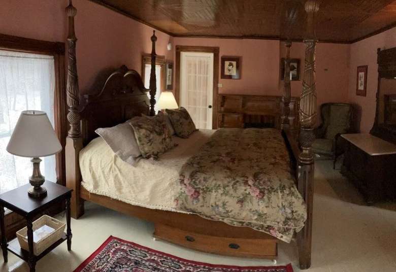 a house bedroom with a bed, a nightstand, a dresser, and a chair