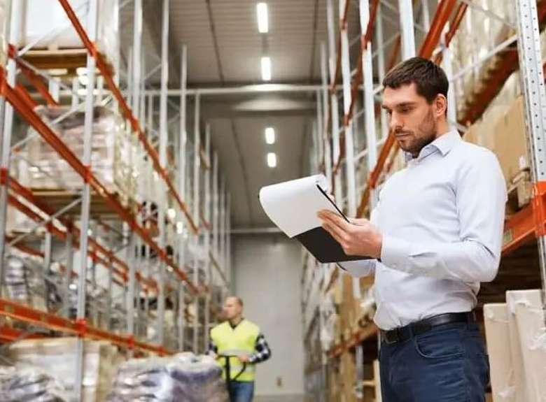 man holding clipboard in a warehouse
