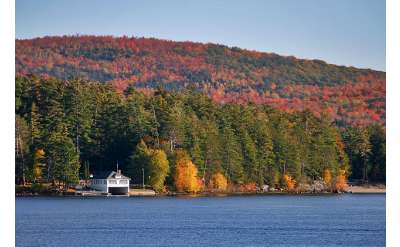 exterior shot of a lake shoreline with fall colors on the trees