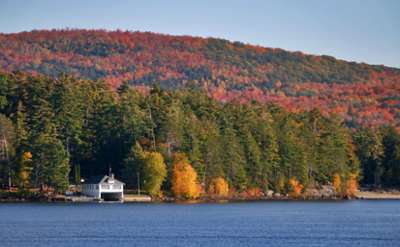 exterior shot of a lake shoreline with fall colors on the trees