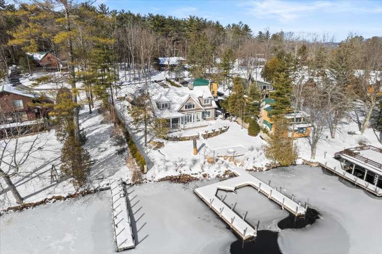 aerial view of a lakeside home and boat docks in the winter