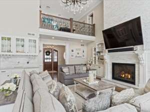 a large living room with couches, a table, a fireplace, and a big tv on the wall