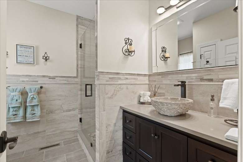 a bathroom with a big sink area and mirror and a glass shower