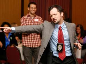 man in suit wearing badge pointing