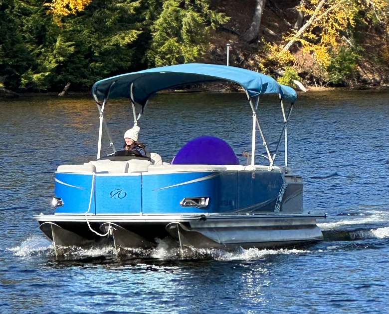 person driving a pontoon boat
