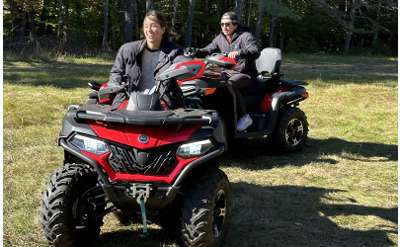 two people riding on red ATVs