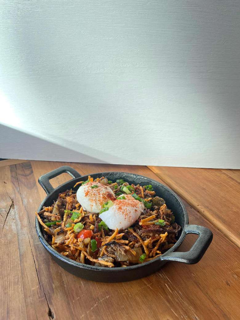 a hash meal with eggs in a skillet