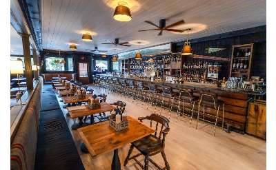 rustic tables in a restaurant dining area and a bar space