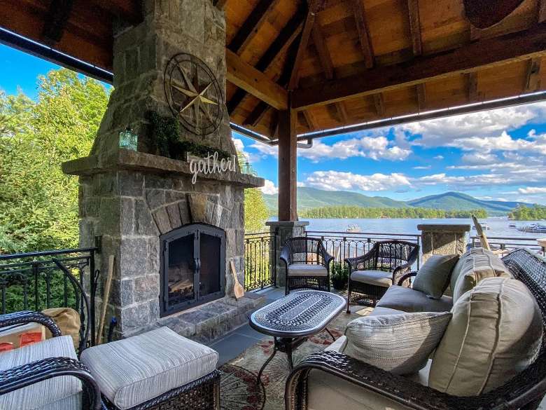 outdoor fireplace seating area with lake views