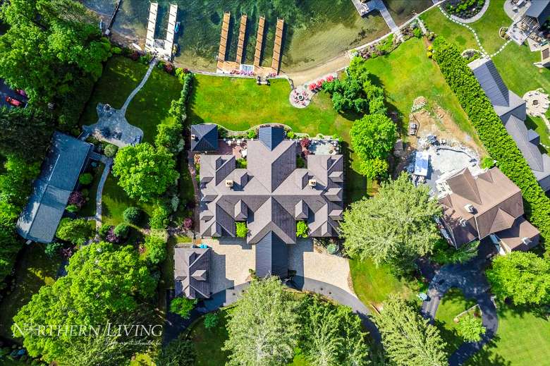 birds eye view of mansion property with dock space on the lake