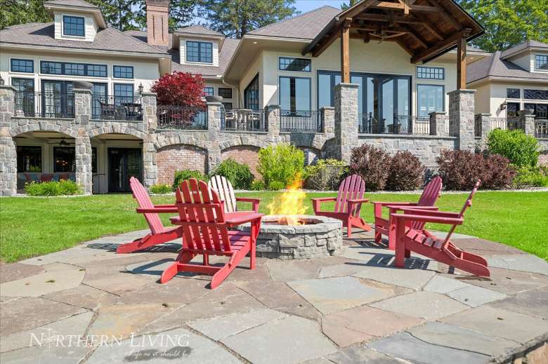 adirondack chairs surrounding a firepit in the backyard