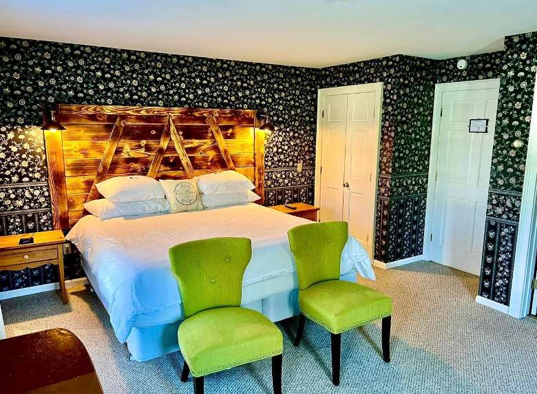 guest room with a bed and two lime green chairs