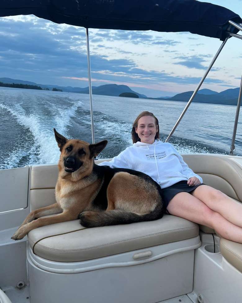a girl sitting with a dog on a boat