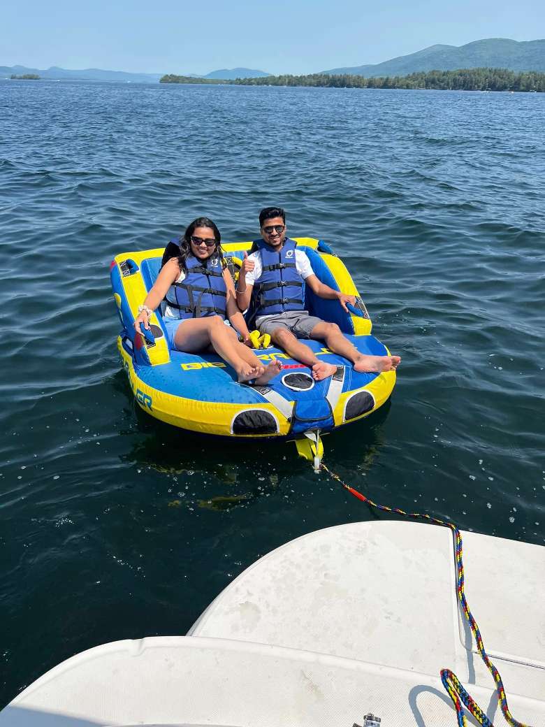 a man and woman on a yellow and blue tube connected to a boat
