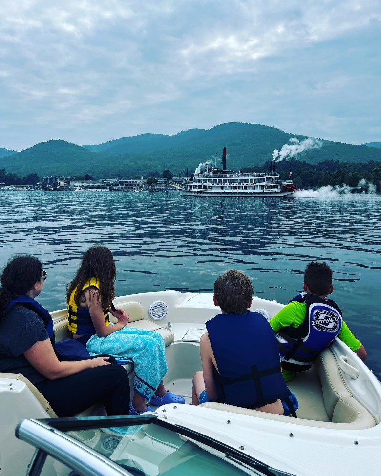 group of people on a boat watching a steamboat