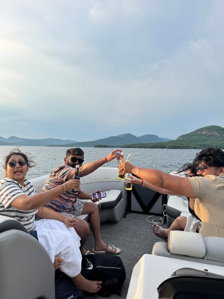 people cheersing with drinks on a lake boat