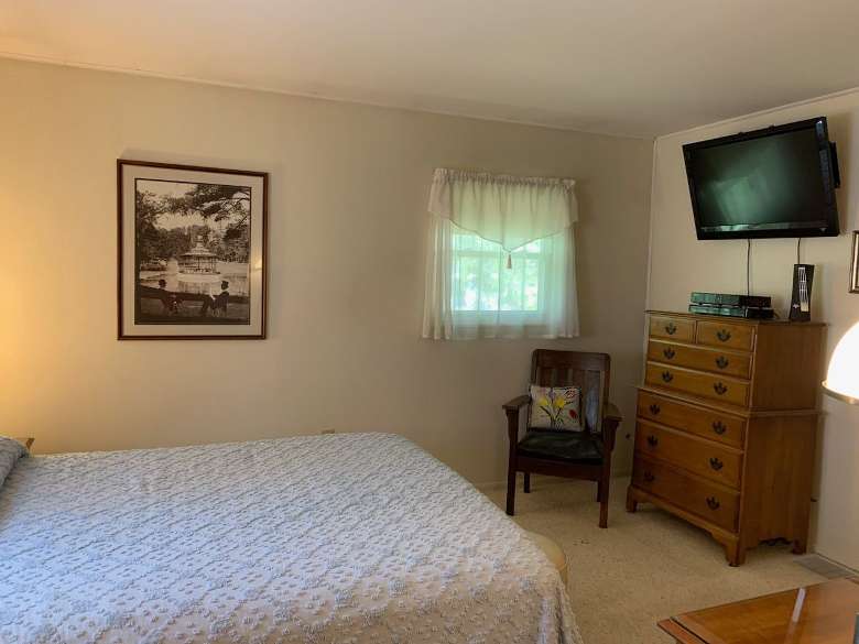 a bedroom with a bed, tv, and dresser