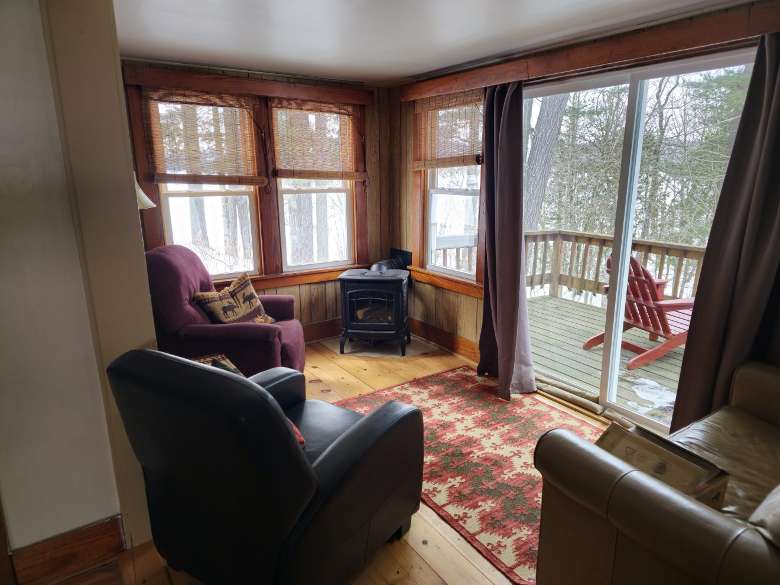 a living room with a wood stove and three chairs