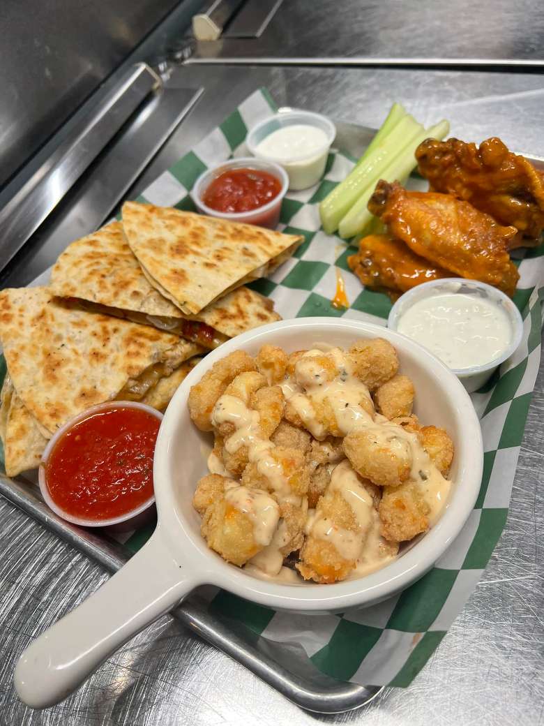 plate with quesadilla, wings, and cheese curds