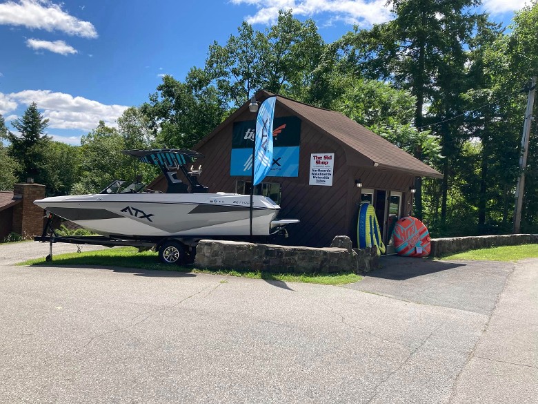 ATX boat outside wooden building