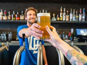 bartender handing customer a beer