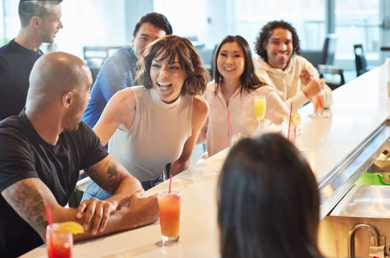 a group of people laughing while seated at a hotel lobby bar