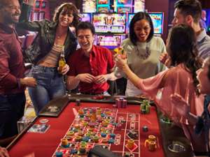 happy people around a gaming table in casino