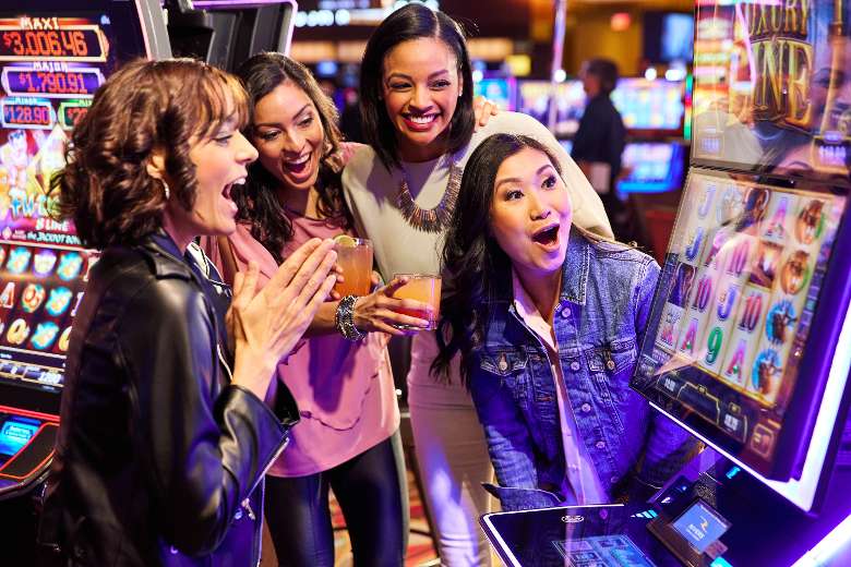 group of women squealing at slot machine