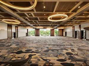 a spacious ballroom with funky carpeting and glass doorways