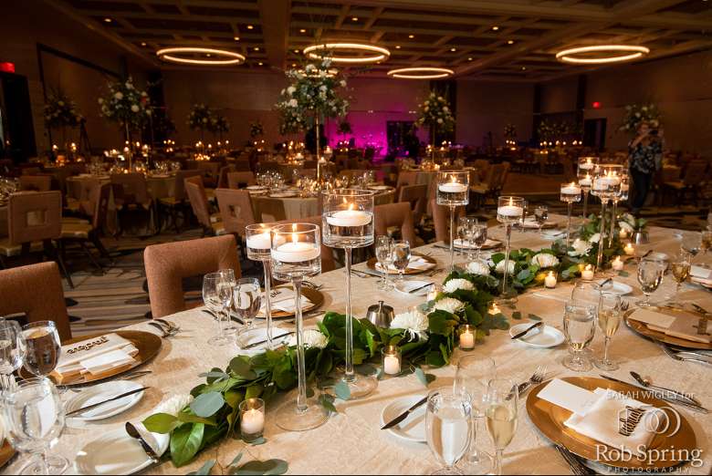a ballroom with tables decorated for a wedding