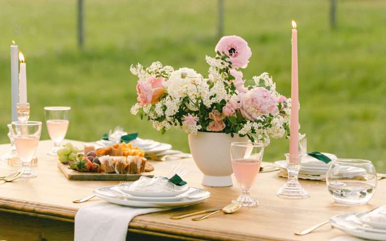 a table with flowers and pink candles