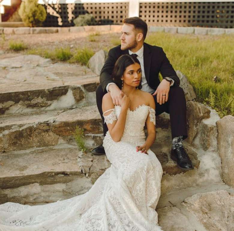 a bride and groom posed on steps