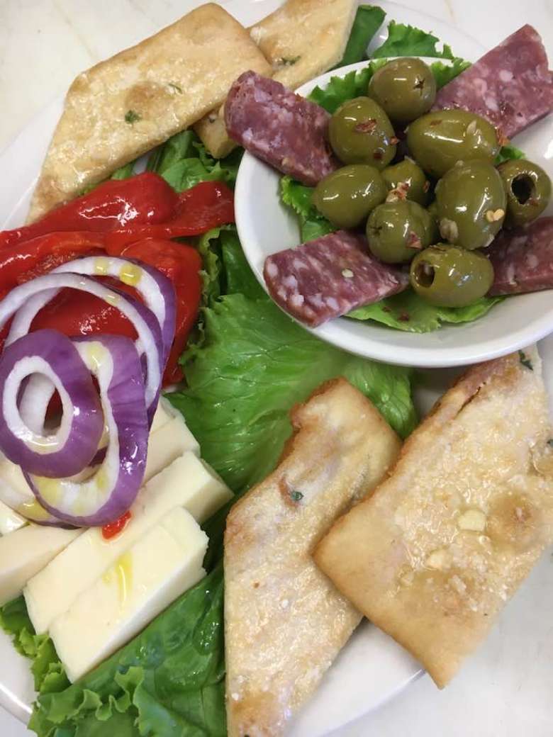 appetizer with bread, olives, meats, cheeses, red peppers, red onions