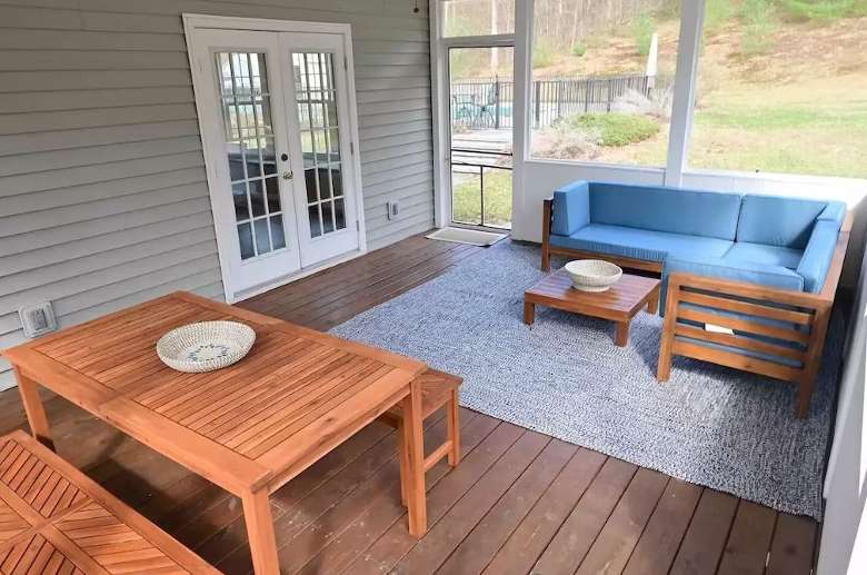porch space with a blue sofa and wooden furniture