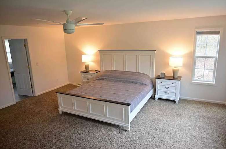 bedroom in a house with a bed, two nightstands, and two lamps