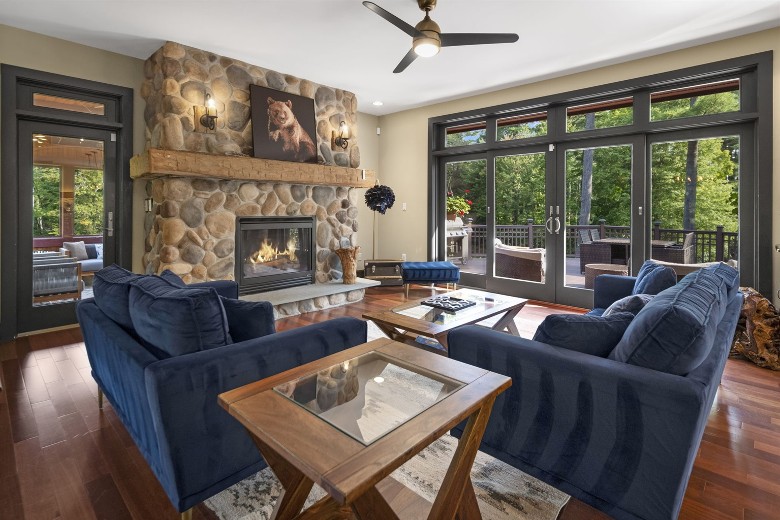 living room with large windows and stone fireplace