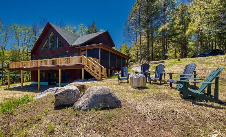 exterior of a rustic home with Adirondack chairs outside