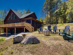 exterior of a rustic home with Adirondack chairs outside