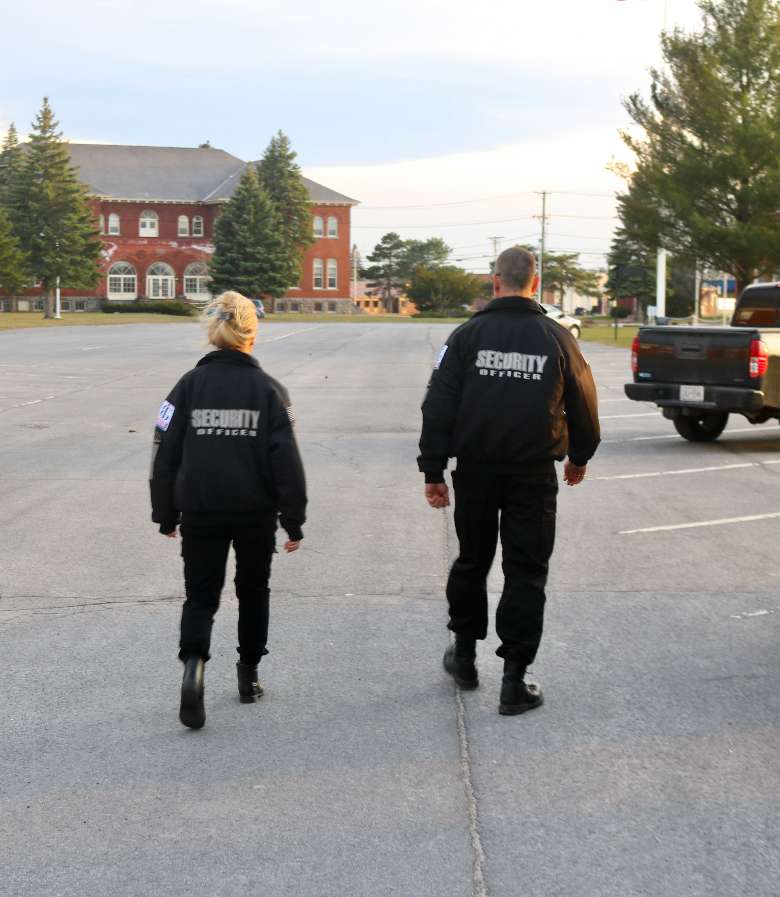 man and woman wearing security jackets