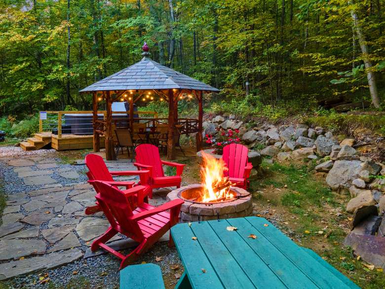 red adirondack chairs around a firepit with a gazebo in the background