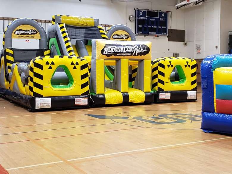 construction-themed bounce obstacle course in a gym