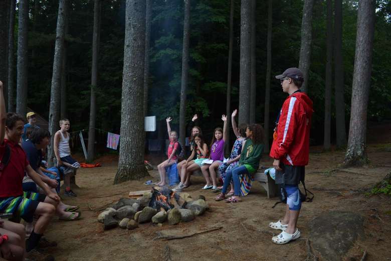 kids and counselors around a campfire