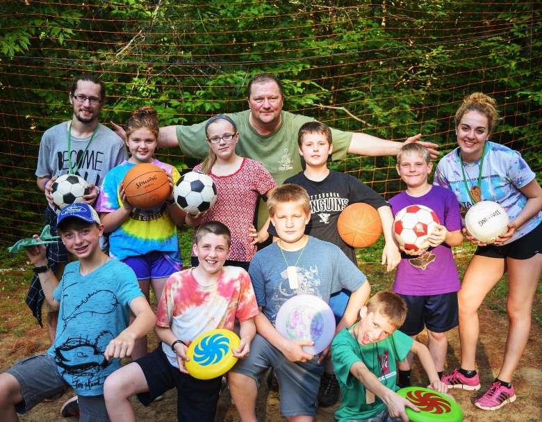 a group of summer campers holding sports equipment