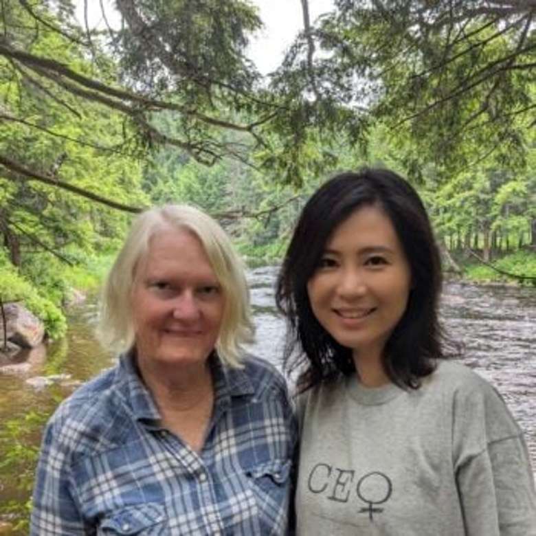 2 women standing in front of a river.