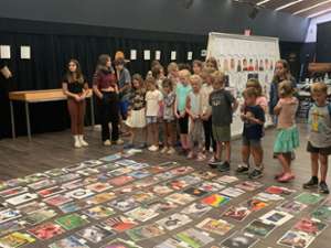 several kids looking at art on the ground