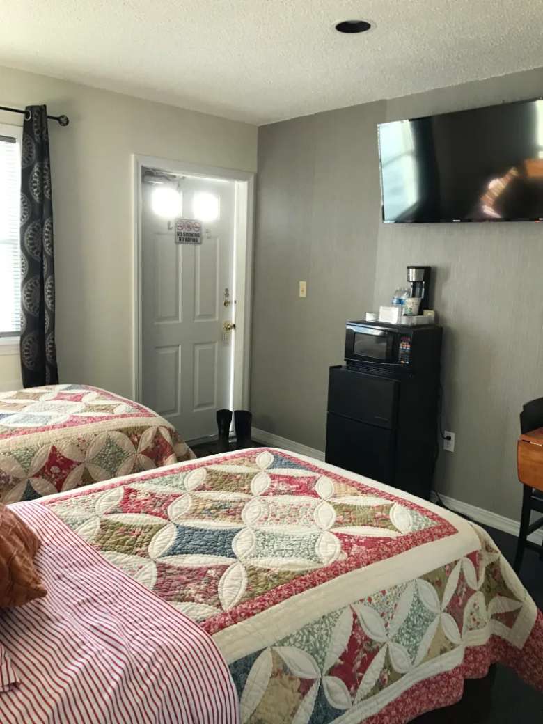 two queen beds and smart tv on wall