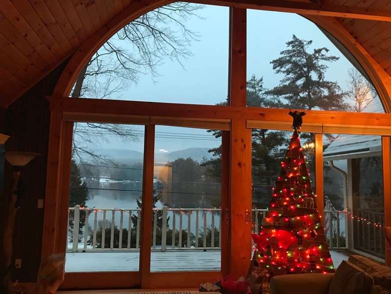 room with christmas tree and large window overlooking deck