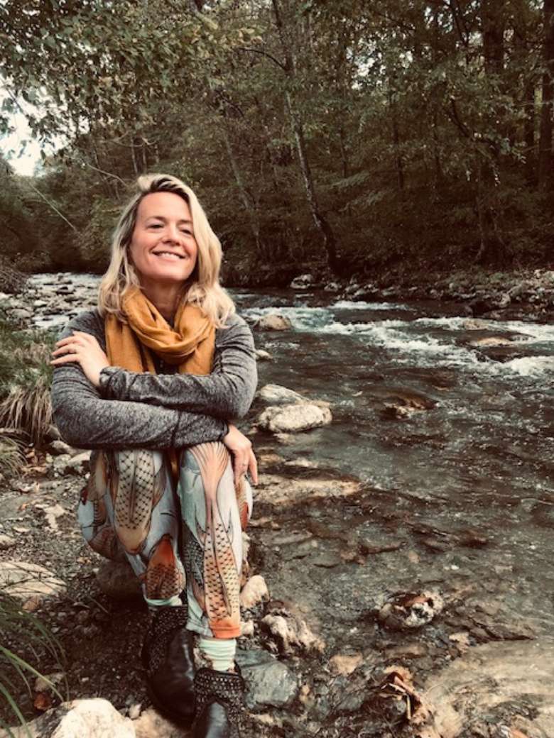 Catherine sitting by a river